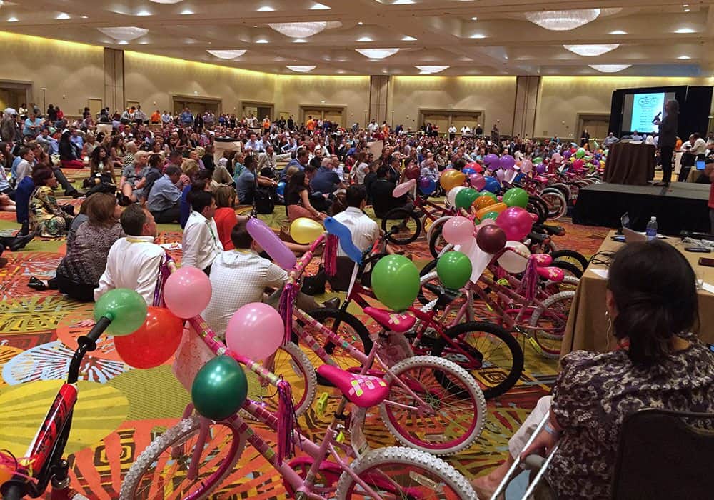 A ballroom full of finished donation bikes with balloons at a Bike Build Donation event
