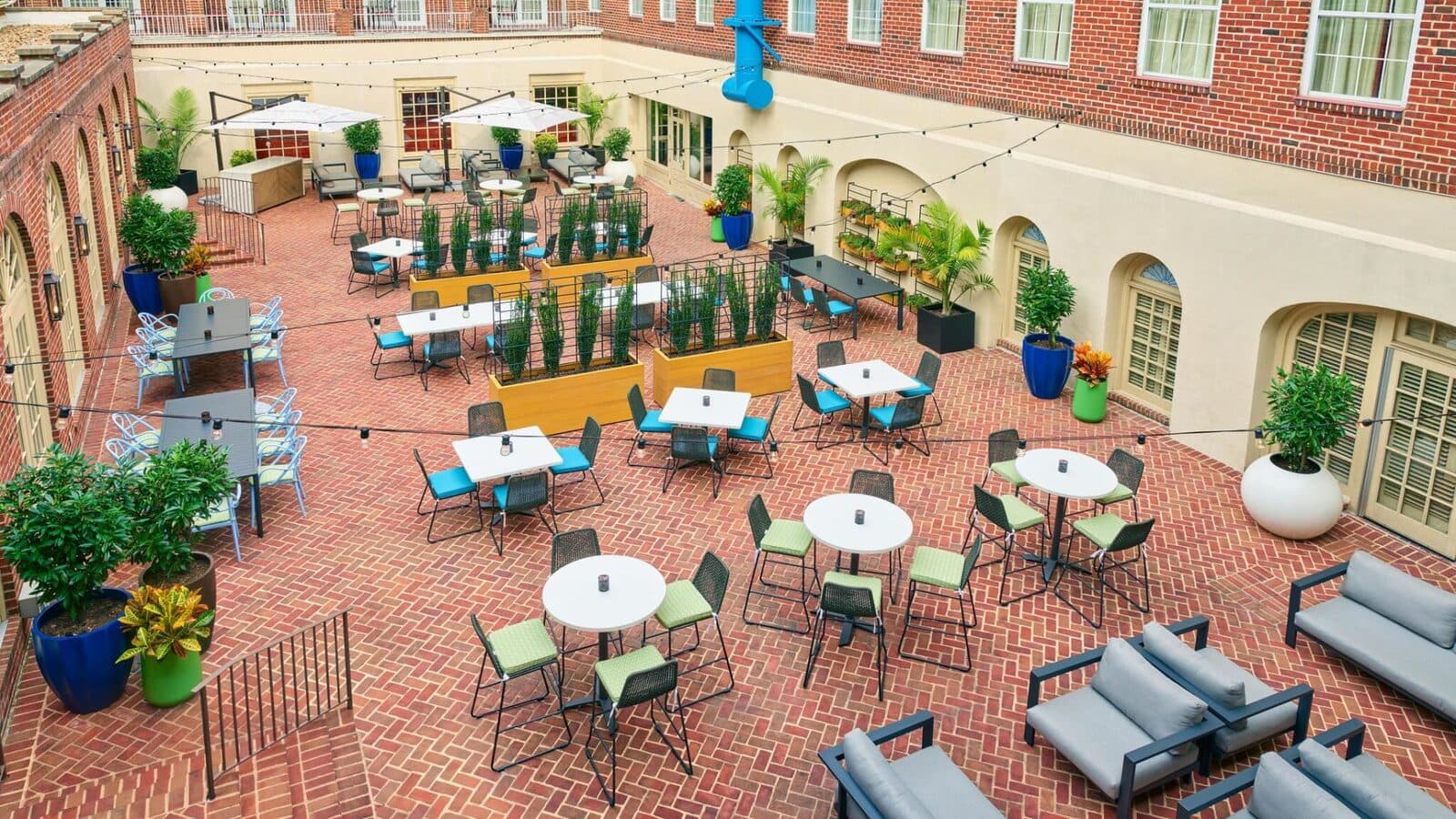 The Alexandrian's brick courtyard garden with bistro tables under string lights, Old Town Alexandria, VA