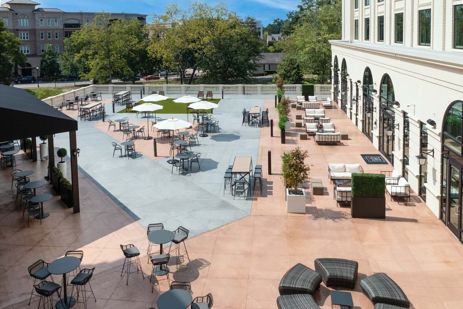 Byers Plaza beside The Hamilton Alpharetta, with umbrella tables, lounge seating and a lawn