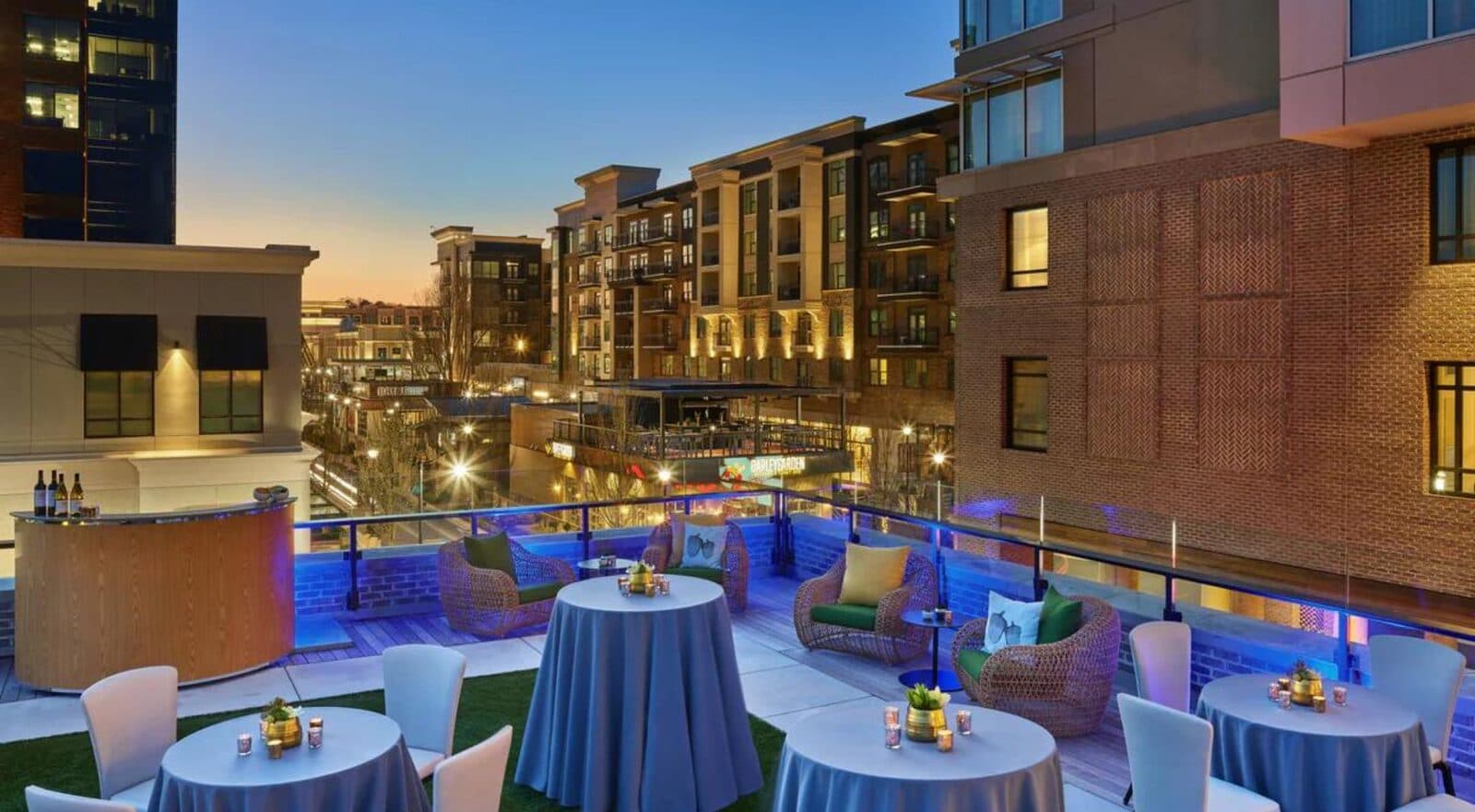 A rooftop terrace at The Hotel at Avalon set with cocktail tables over Avalon at dusk