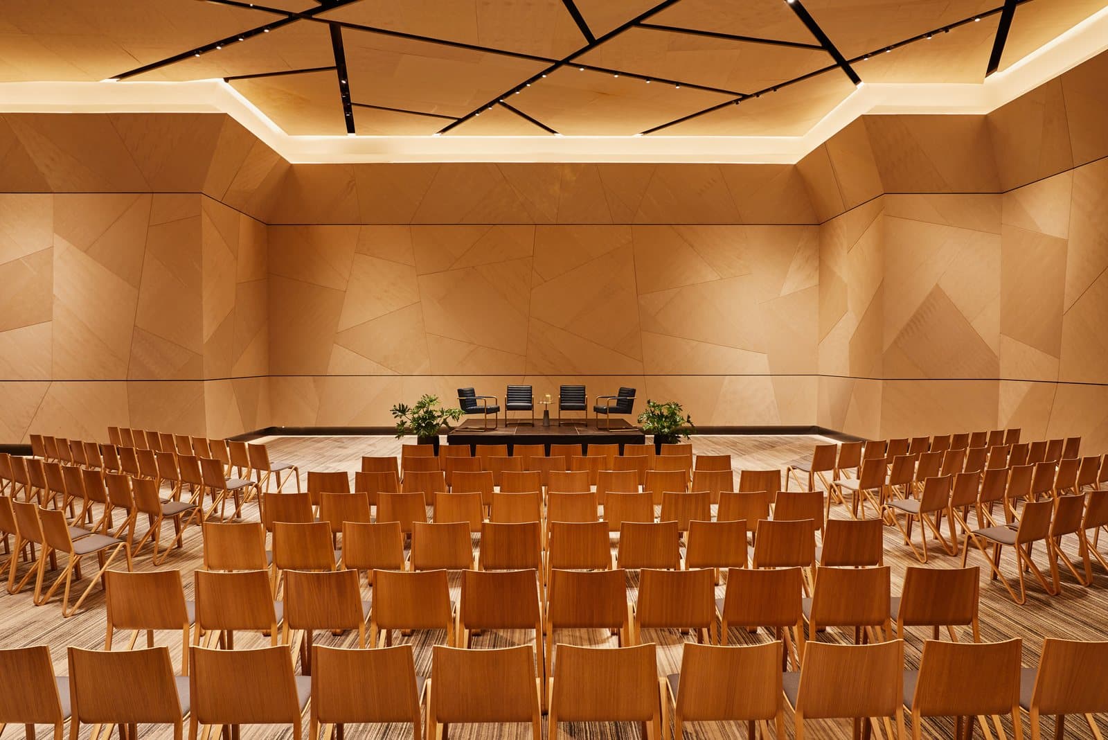 The William Vale's wood-paneled event space set with rows of chairs facing a stage, Williamsburg, Brooklyn