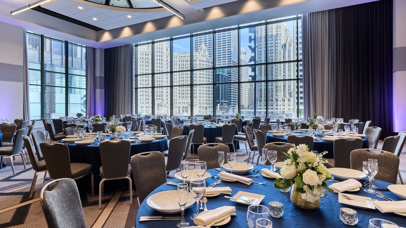 Hyatt Regency Chicago's Crystal Ballroom set with banquet rounds, downtown towers in the windows
