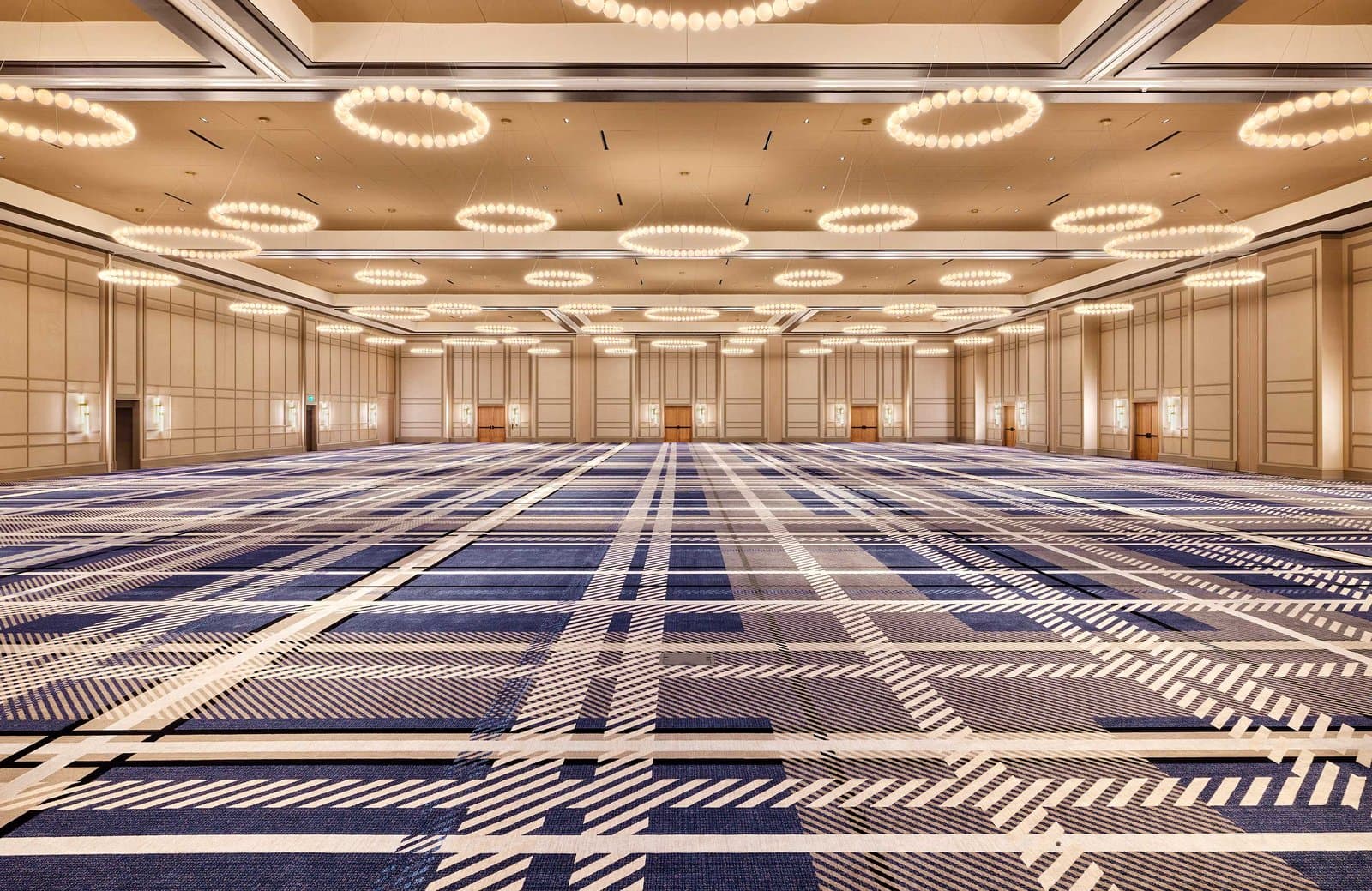 The Ryder Cup Ballroom at Omni PGA Frisco Resort in Frisco, Texas, empty under rings of pendant lights