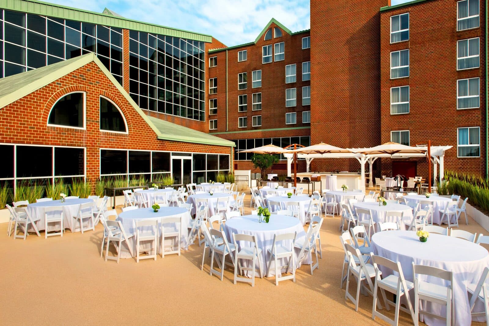 The Newport Marriott's Hideaway Terrace set with round tables and cabanas on a sunny day