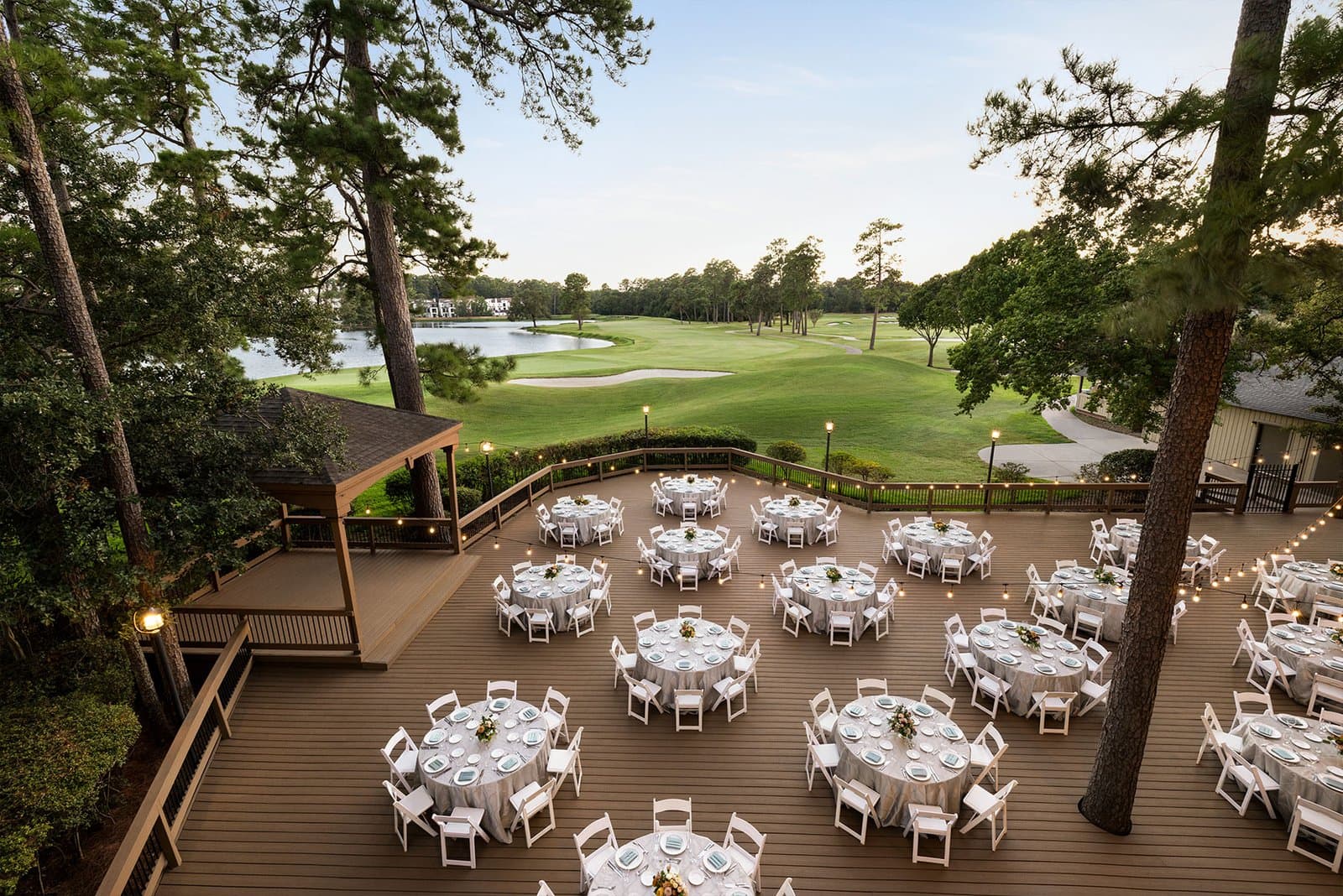 Forest Deck at The Woodlands Resort in The Woodlands, Texas, set with round tables under pine trees beside the golf course