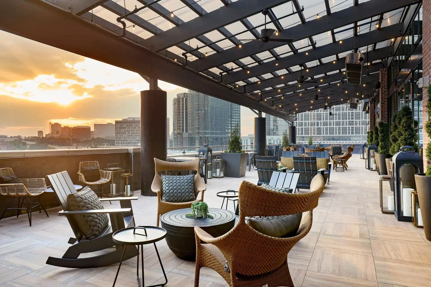 The rooftop terrace at Archer Hotel Tysons with lounge seating at sunset over the Tysons skyline, Tysons, VA