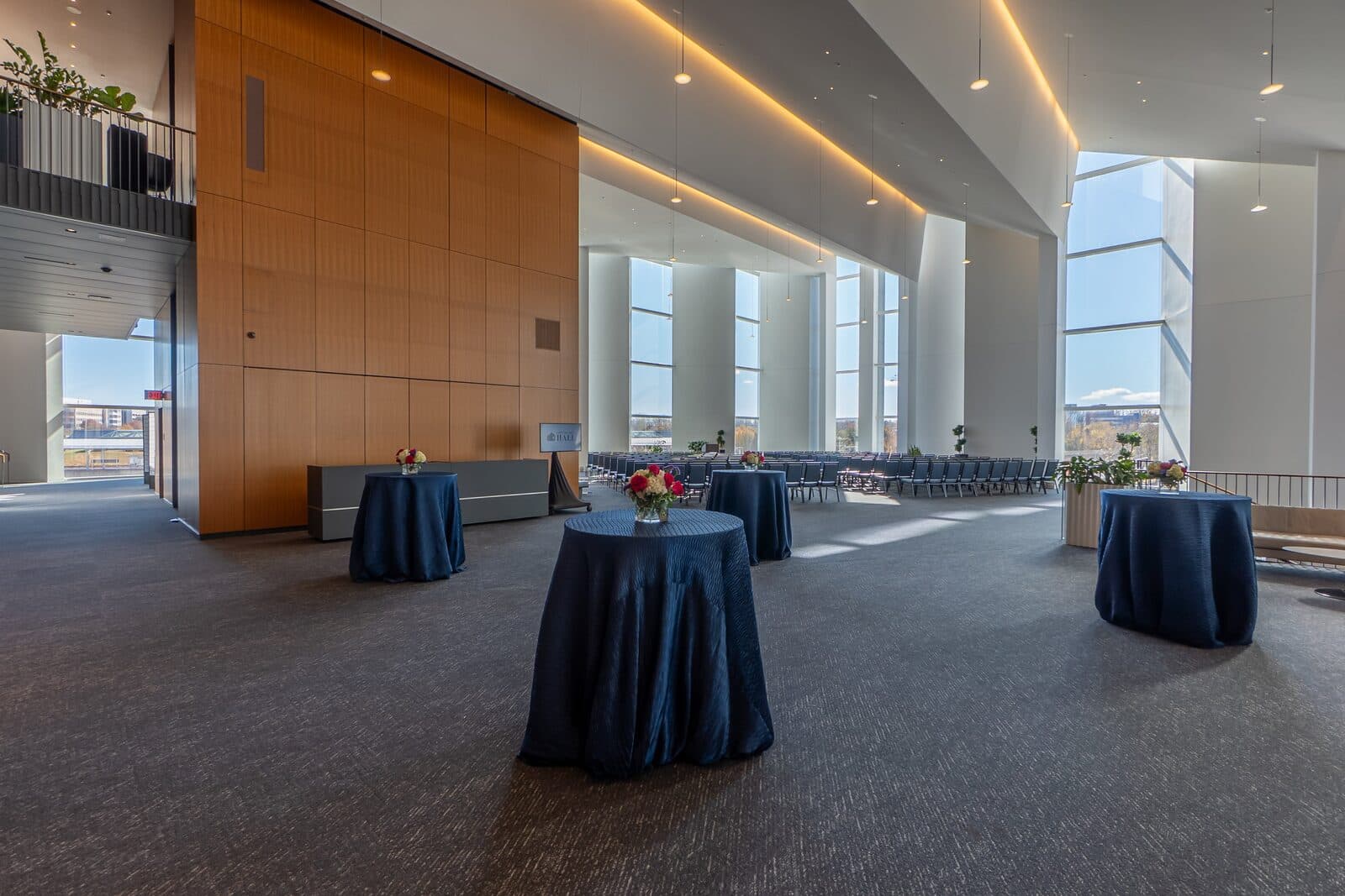 The sunlit four-story Atrium at Capital One Hall set with cocktail tables for a reception, Tysons, VA