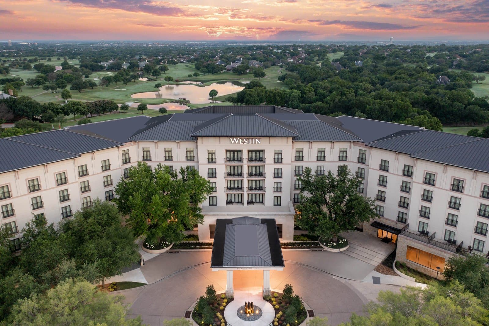 Aerial dusk view of The Westin Dallas Stonebriar Golf Resort and Spa in Frisco, Texas, with its golf course behind the hotel
