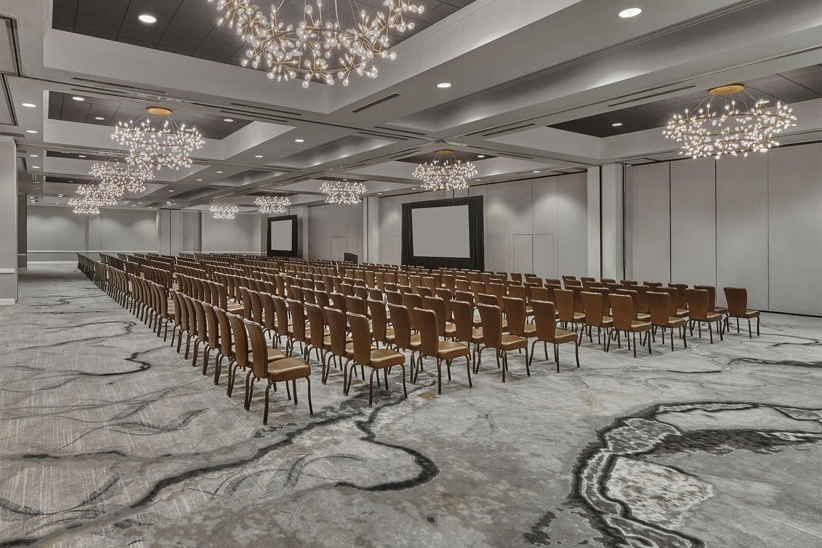The ballroom at The Meritage Resort and Spa in Napa, CA set theater style with rows of chairs facing a screen