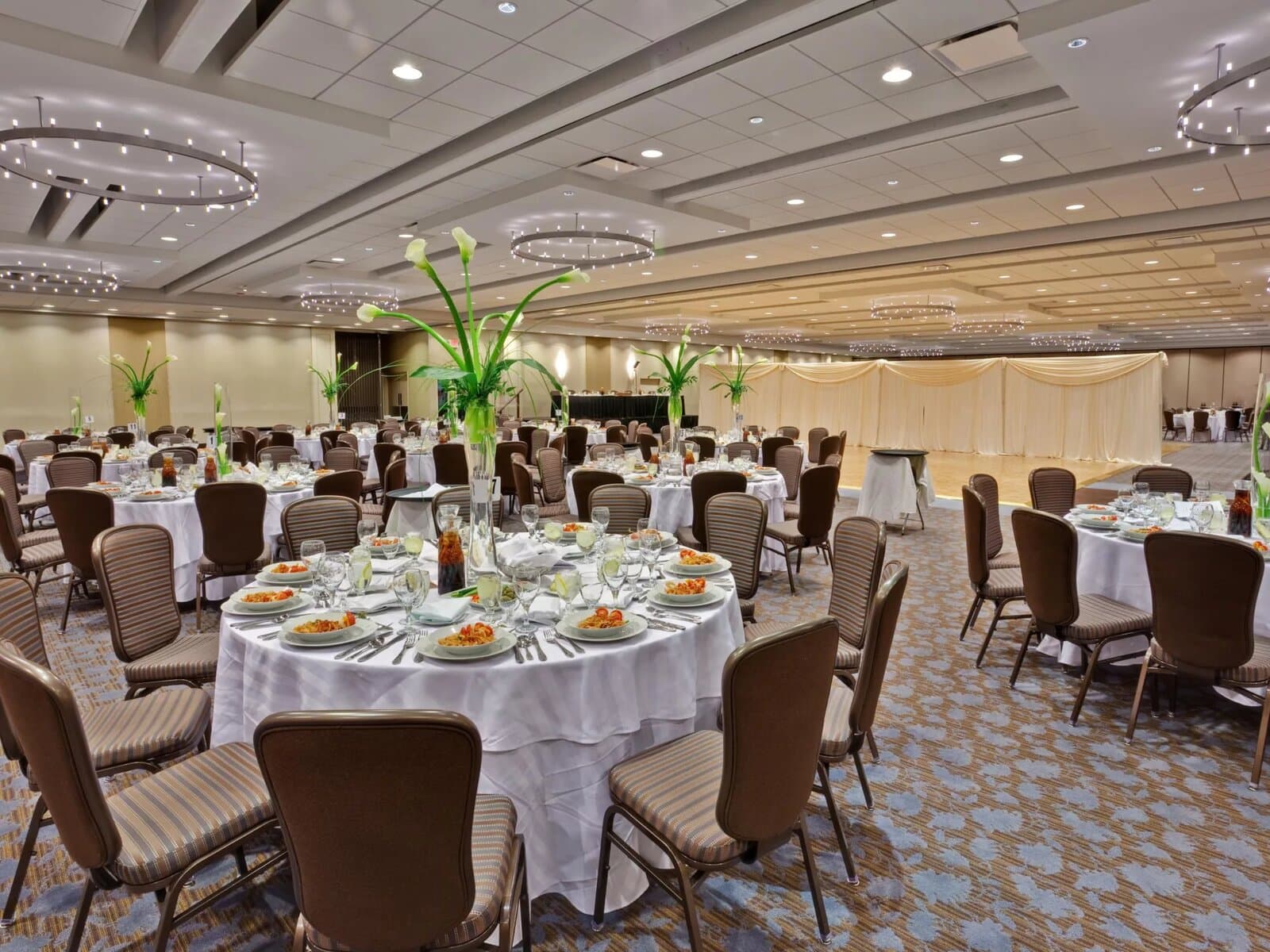 A Crowne Plaza Chicago O'Hare banquet room set with round tables and centerpieces, Rosemont, IL