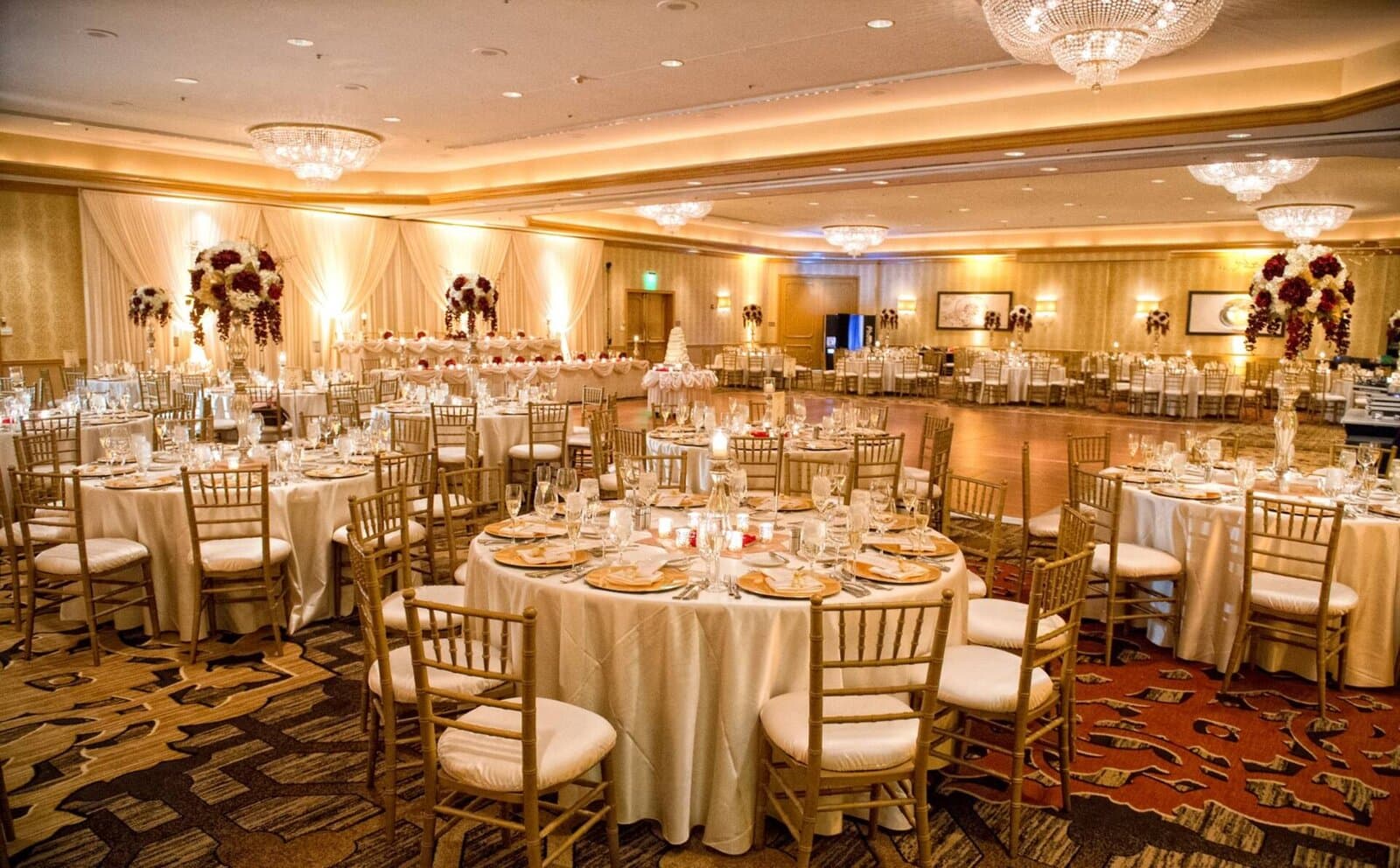 The Hilton Rosemont ballroom set for a reception with round tables under chandeliers, Rosemont, IL