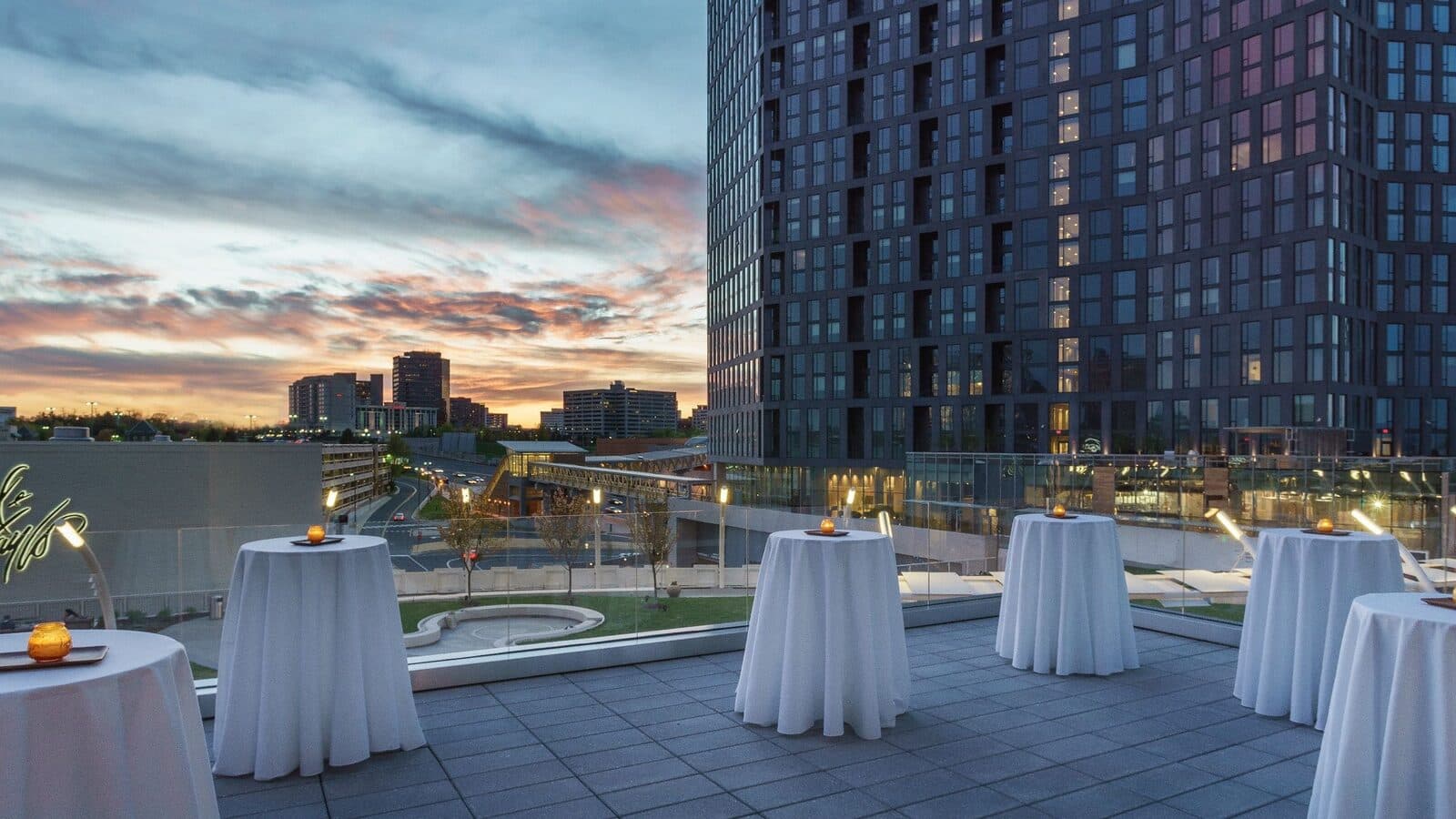 The Peach Grove terrace at Hyatt Regency Tysons Corner Center set with cocktail tables at sunset, Tysons, VA
