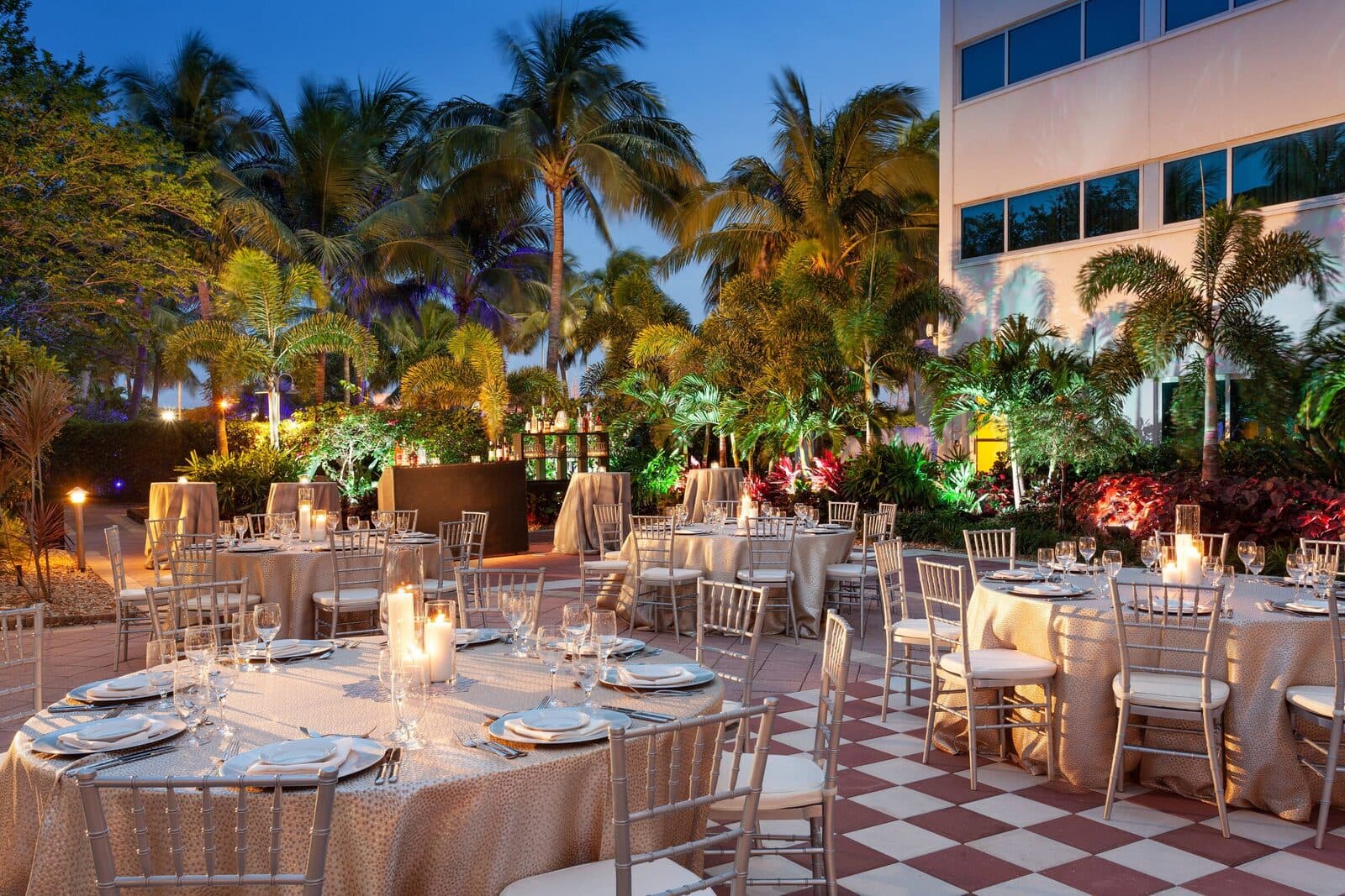 The West Palm Beach Marriott courtyard set for an evening dinner among lit palms