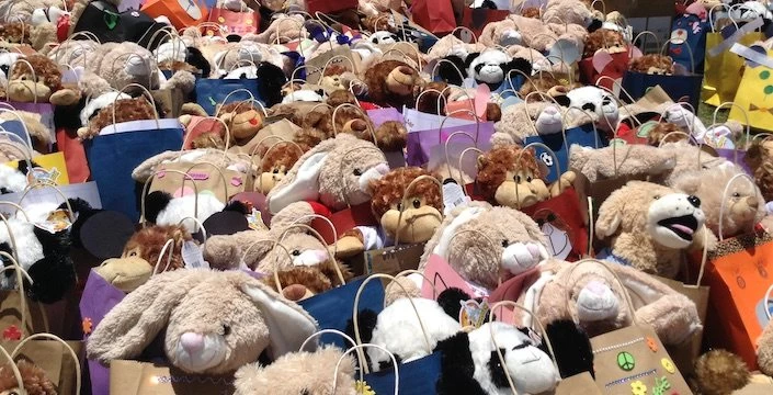 A group of stuffed animals are lined up on a sidewalk.