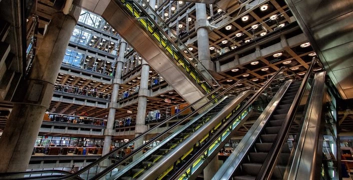 An escalator in a large building with many floors.