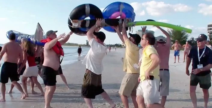A group of people on a beach with inflatable rafts.