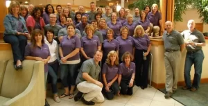 A group of people in purple shirts posing for a photo.