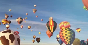 Many colorful hot air balloons flying in the sky.