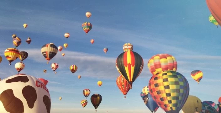 Many colorful hot air balloons flying in the sky.
