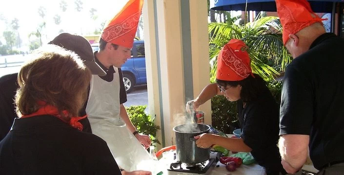 A group of people wearing orange hats at a table.