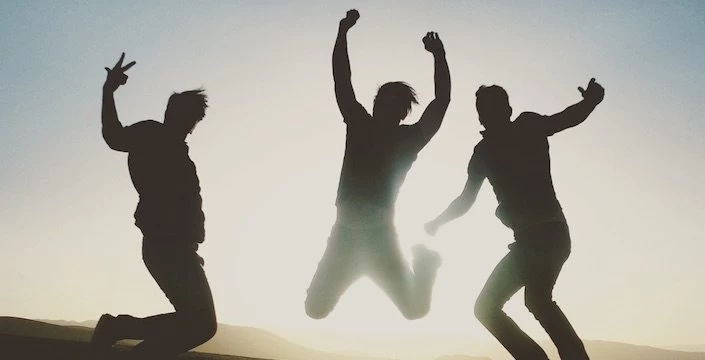 Three silhouettes of people jumping in the air.
