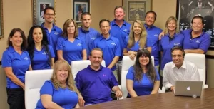 A group of people in blue shirts posing for a picture.