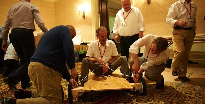 A group of men working on a wooden cart.