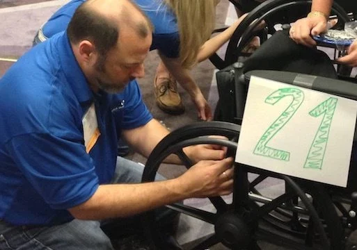 A group of people working on a wheelchair.