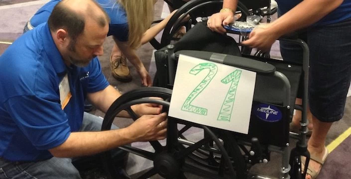 A group of people working on a wheelchair.