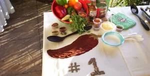 A table with a number of ingredients and utensils on it.