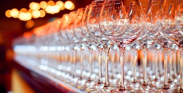 A row of wine glasses lined up on a table.