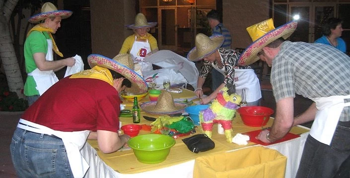 Men in mexican hats preparing food at a table.