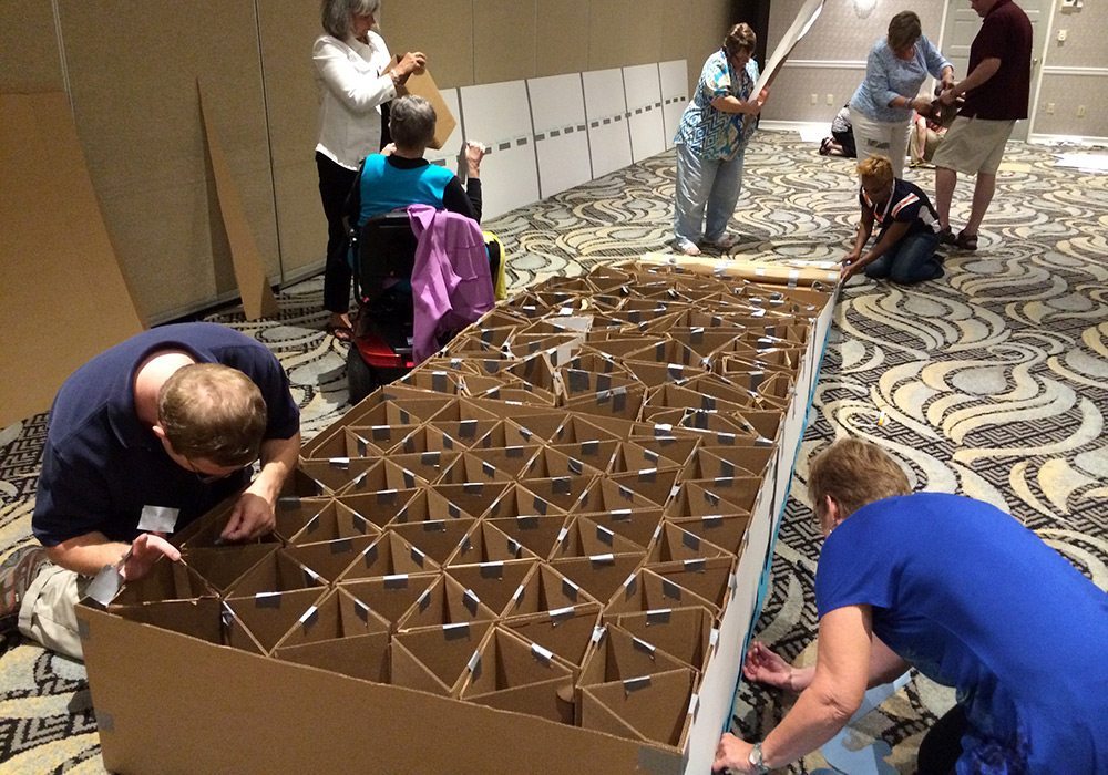 A group of people working on a cardboard box.