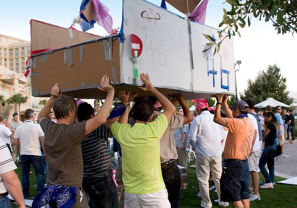 A group of people carrying a cardboard box.