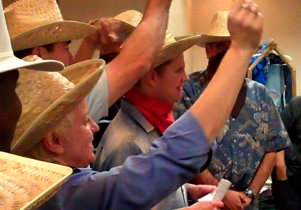 A group of people wearing cowboy hats in a room.
