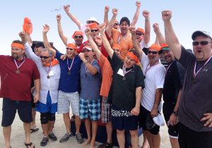 A group of people posing for a picture on the beach.