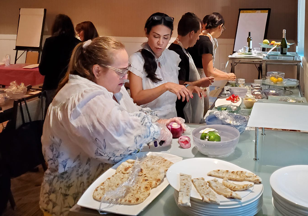 A group of people preparing food at a buffet.