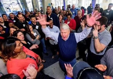 A crowd of people with their hands up in the air.