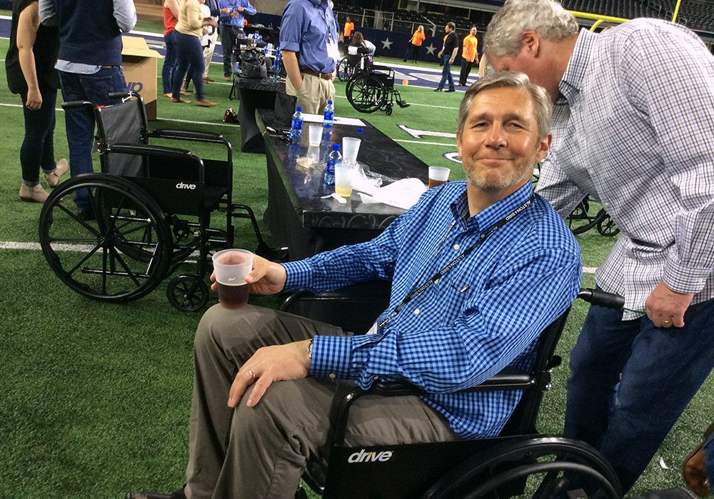 A man sitting in a wheelchair at a football game.