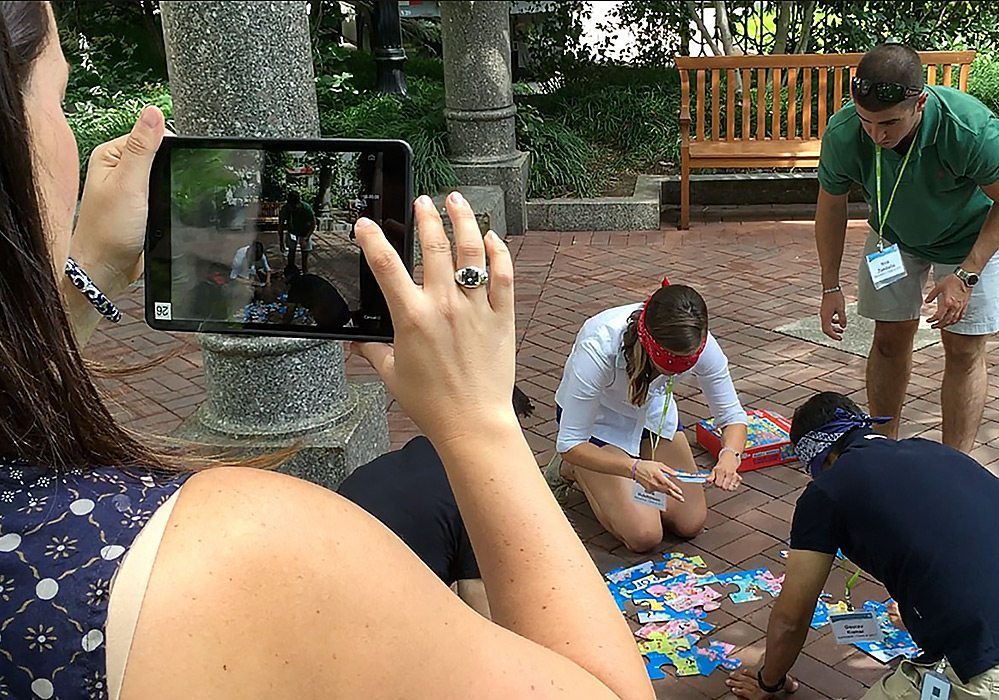 A group of people taking a picture with an ipad.