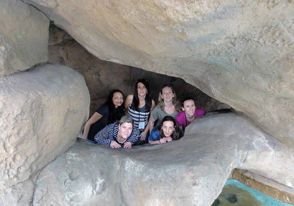 A group of people posing in a cave.