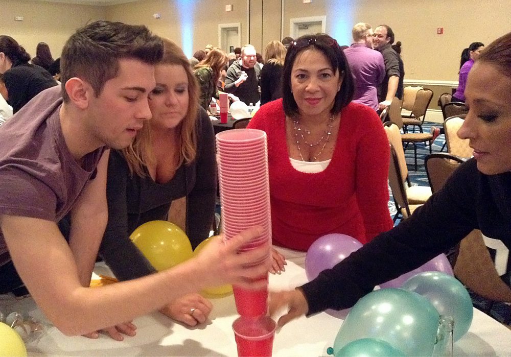 A group of people standing around a table with balloons.