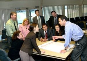 A group of business people standing around a table.