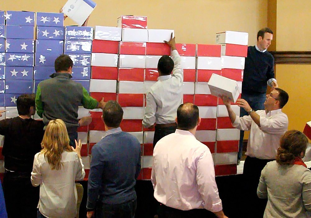 A group of people standing around an american flag.