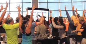 A group of people raising their hands in the air.