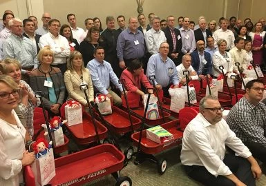 A group of people posing in red wagons.