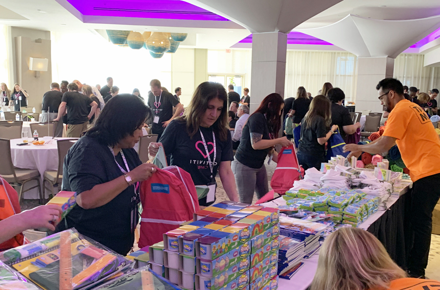 A group of people standing around a table full of books.