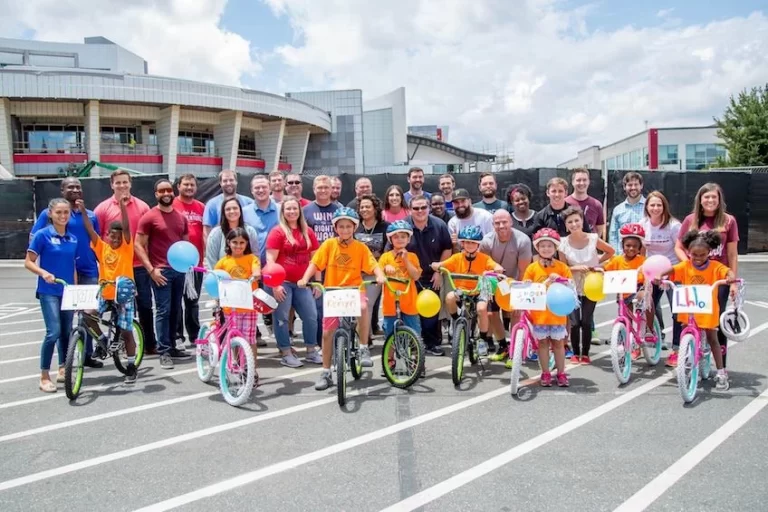 A group of people posing for a photo with bicycles as part of a CSR initiative.