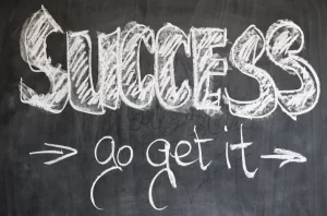 "Success go get it" written in chalk on a blackboard at corporate events.