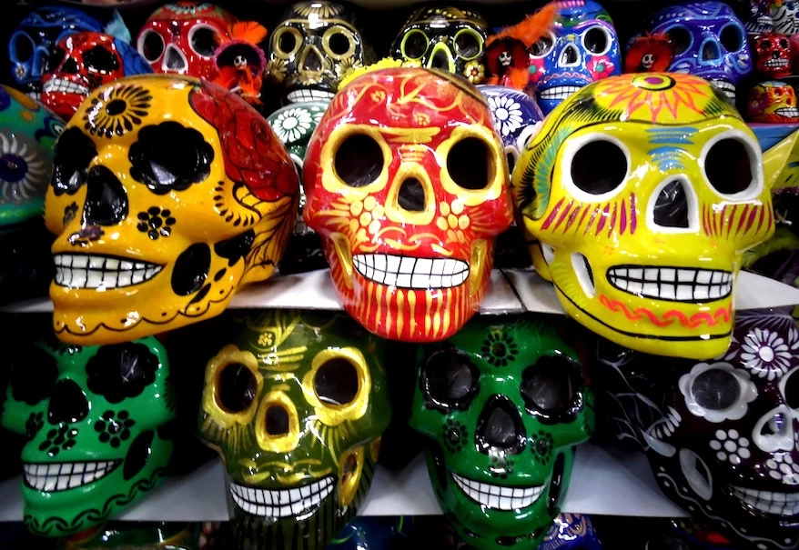 A row of colorful sugar skulls in a dia de los muertos store.